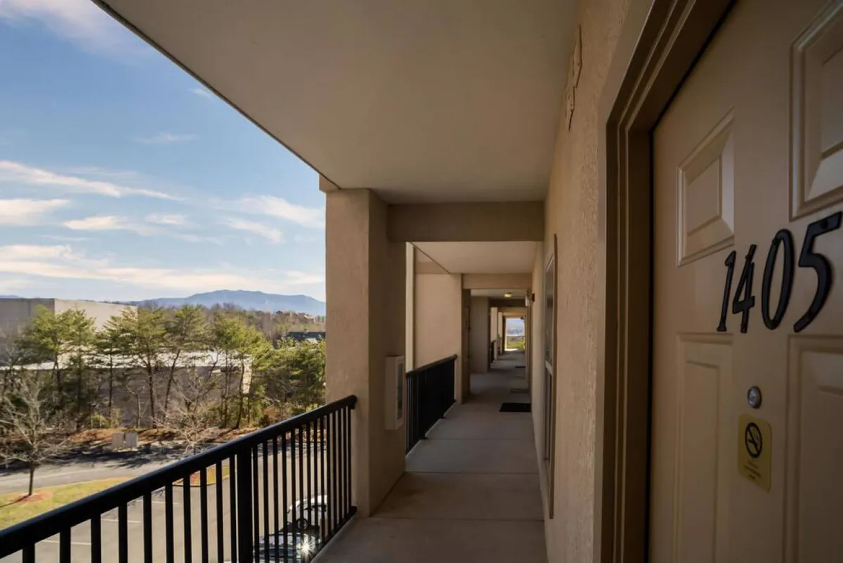 A balcony view with a railing looking out onto beautiful mountain scenery. The door to the unit (number 1405) is visible, offering a sense of privacy and exclusivity. The inviting outdoor space is perfect for enjoying fresh air and panoramic views.